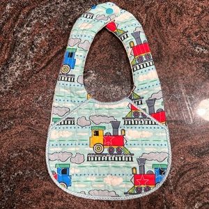 Handmade reversible quilted baby bib in train print